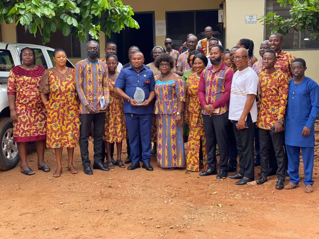 Mr John Kwame Duodu (Sir John) holding the plaque presented to him as Mrs Essel-Cudjoe, Municipal Director of Education stands close to him as well as officers from the Directorate in a group picture.