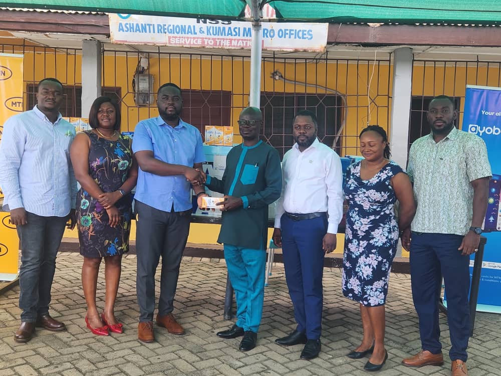 Mr Kofi Adu Acheampong (3rd left), Ashcell Limited Officer presenting an item to the Prince Kankam Boadu (4th right), Ashanti Regional Director of NSS